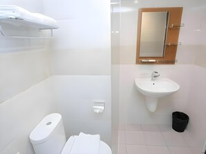 Ein modernes Badezimmer mit Toilette, Waschbecken und Spiegel.