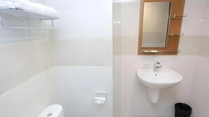 Moderni kylpyhuone, jossa on wc, pesuallas ja peili.