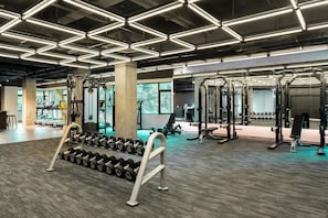 A gym with weightlifting equipment, dumbbells, and exercise machines. - Shenzhen Innogym Hotel (Shenzhen)
