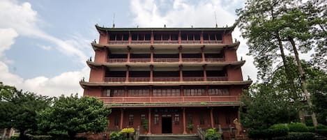 A multi-story traditional building with a symmetrical facade, multiple balconies, and a central entrance.