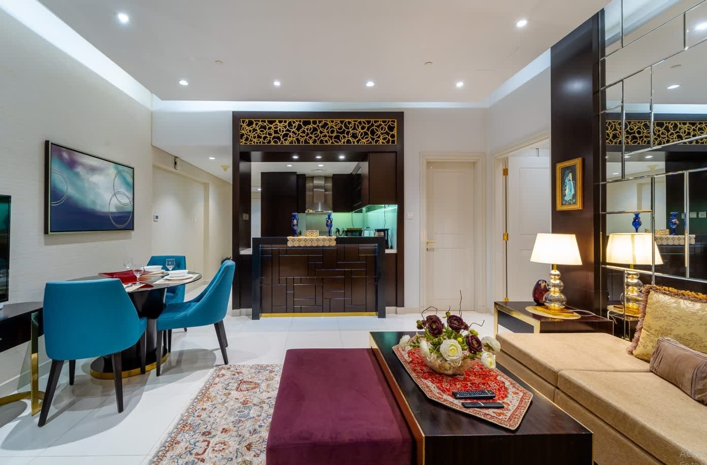 Uma sala de estar moderna com área de jantar, cozinha ao fundo e um espelho grande refletindo o ambiente.