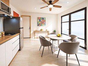 Eine moderne Küche mit Essbereich, Deckenventilator und großem Fenster für natürliches Licht.