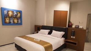Ein Hotelzimmer mit einem Bett, einem Nachttisch, einem Holzschrank und einem Bild an der Wand.