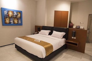 A hotel room with a bed, a nightstand, a wooden wardrobe, and a painting on the wall. - Hotel GM 253 (Patrang)