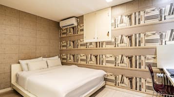 A modern bedroom with a large bed, built-in bookshelves, and a desk with a chair.