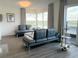 A modern living room with a sofa, a coffee table, and a decorative tray with glasses.