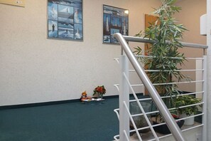Eine Treppe mit Metallgeländer, einem Blumentopf und einer kleinen Figur auf dem Boden.