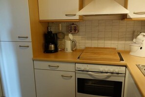 Eine Küche mit weißen Schränken, einer Kaffeemaschine, einem Wasserkocher und einem Toaster.