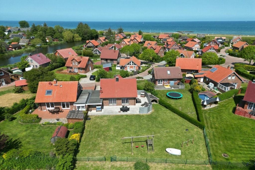 A residential area with houses, a river, and a view of the sea.