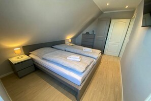 Makuuhuone, jossa on sänky, yöpöydät ja lamppu.
