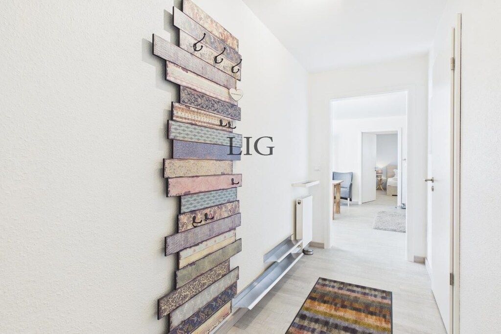 A hallway with a wall-mounted wooden art piece and a radiator.
