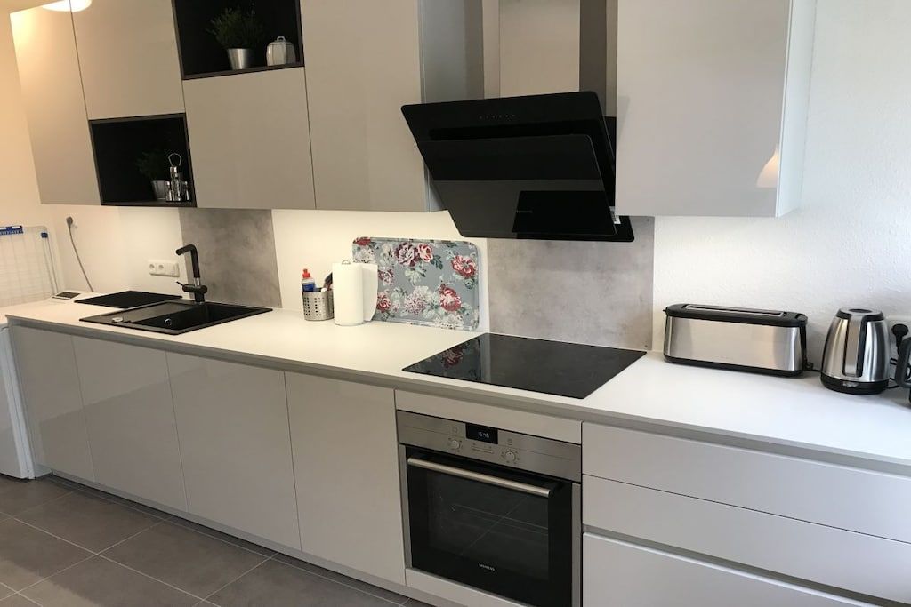 A modern kitchen with a built-in oven, a sink, and a toaster.