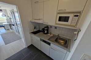 A kitchen with a microwave, sink, and coffee maker. - South Beach happiness (Burgtiefe-Südstrand)