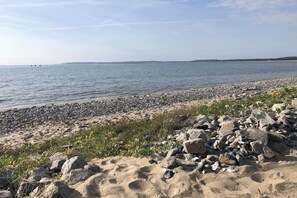 A beach with pebbles and sand, a clear sky, and calm water. - Holiday home in Sassnitz with swimming pool (Sassnitz)