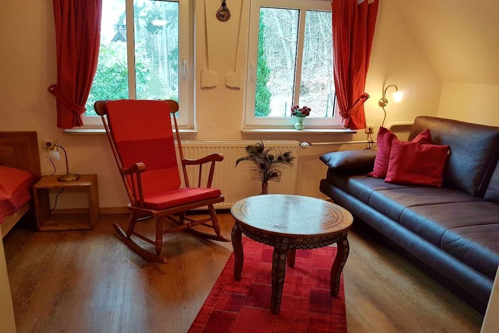 Ein gemütliches Wohnzimmer mit Rockstuhl, Sofa und einem kleinen Tisch.