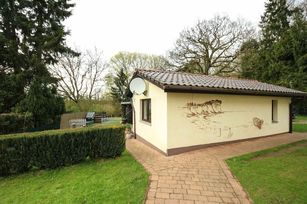 Un petit bâtiment avec un toit recouvert de tuiles, une antenne parabolique et une fresque sur le mur latéral.