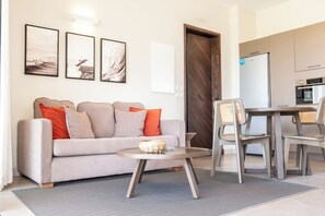 Ein Wohnzimmer mit einer Couch, einem Couchtisch und einem Essbereich mit Stühlen und Tisch.