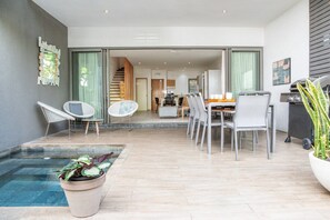 Un espace de vie moderne comprenant un coin repas, un escalier et une petite piscine.