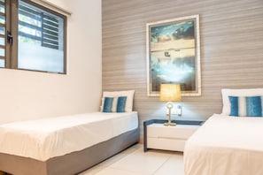 A hotel room with two beds, a nightstand, a lamp, and a painting on the wall. - Amazing Sunsets & Plunge Pool - Walk to Everything (Grande Riviere Noire)