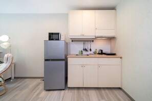 A compact kitchen with a built-in microwave, a double-door refrigerator, and a sink. - Direct Pool Access - Modern 1BR - 104 @ The Title - Walk to Beach & Airport (Sakhu)