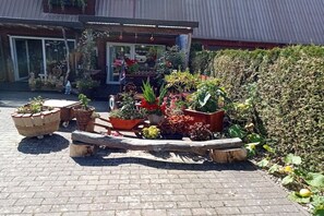 A garden area with potted plants and a wooden bench. - Holiday apartment with 2 bedrooms (Papenhagen)