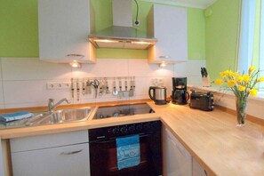 A compact kitchen with a dishwasher, oven, and a coffee maker. - Baltic Sea with sea view and balcony (Dahme)