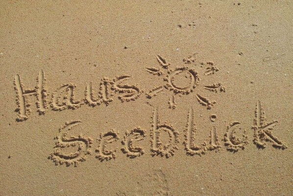 Sand with the words 'Haws Seeblick' and a sun symbol. - Baltic Sea with sea view and balcony (Dahme)