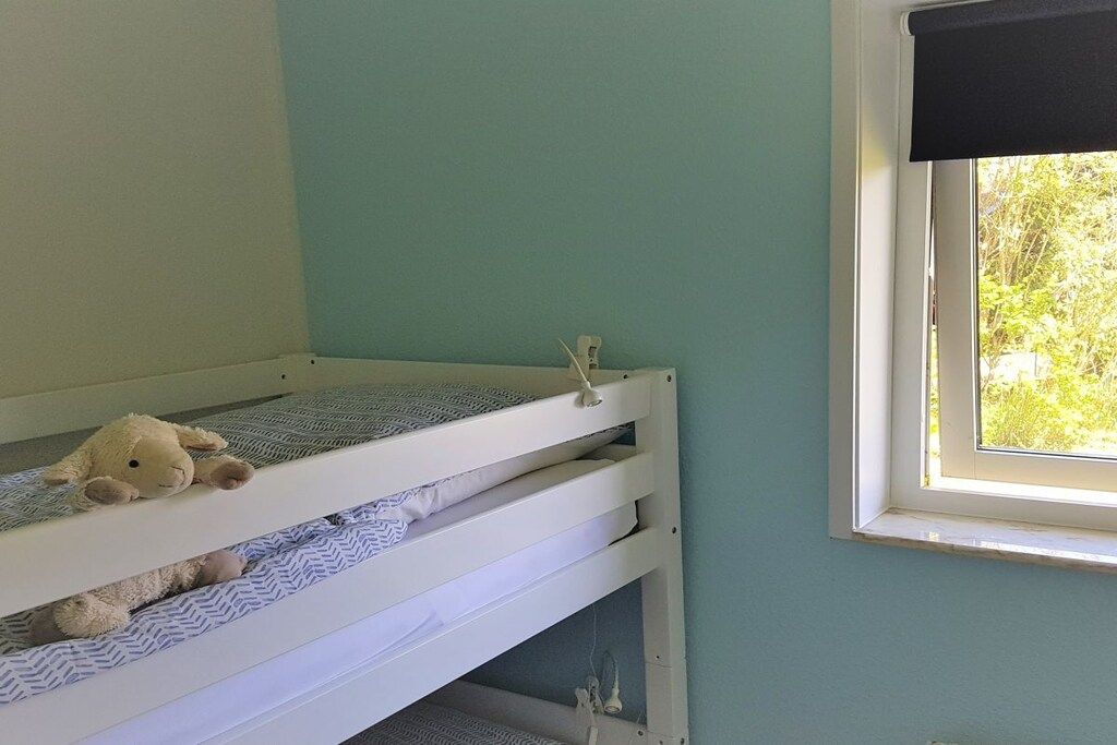 Een stapelbed met een raam aan de rechterkant.