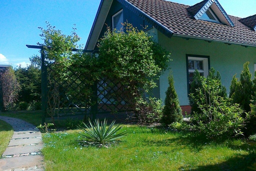 A house with a sloped roof, a visible window, and a pathway leading to the entrance.