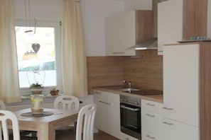 A compact kitchen with a built-in oven, a sink, and white cabinetry. - Holiday apartment in Büsum with swimming pool (Büsum)