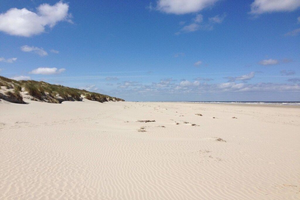 Una platja sorrenca amb dunes i un cel serè.