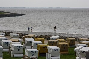 A beachside area with numbered beach chairs and a view of the sea. - Dat Fischerhus - Ground Floor (Büsum)