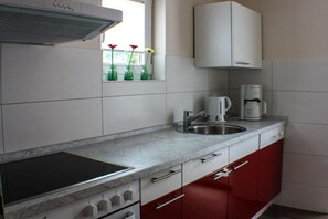 A kitchen with a stove, sink, and cabinets. - Dat Fischerhus - Ground Floor (Büsum)