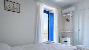 Une chambre à coucher avec un lit, une armoire et une fenêtre avec des rideaux.