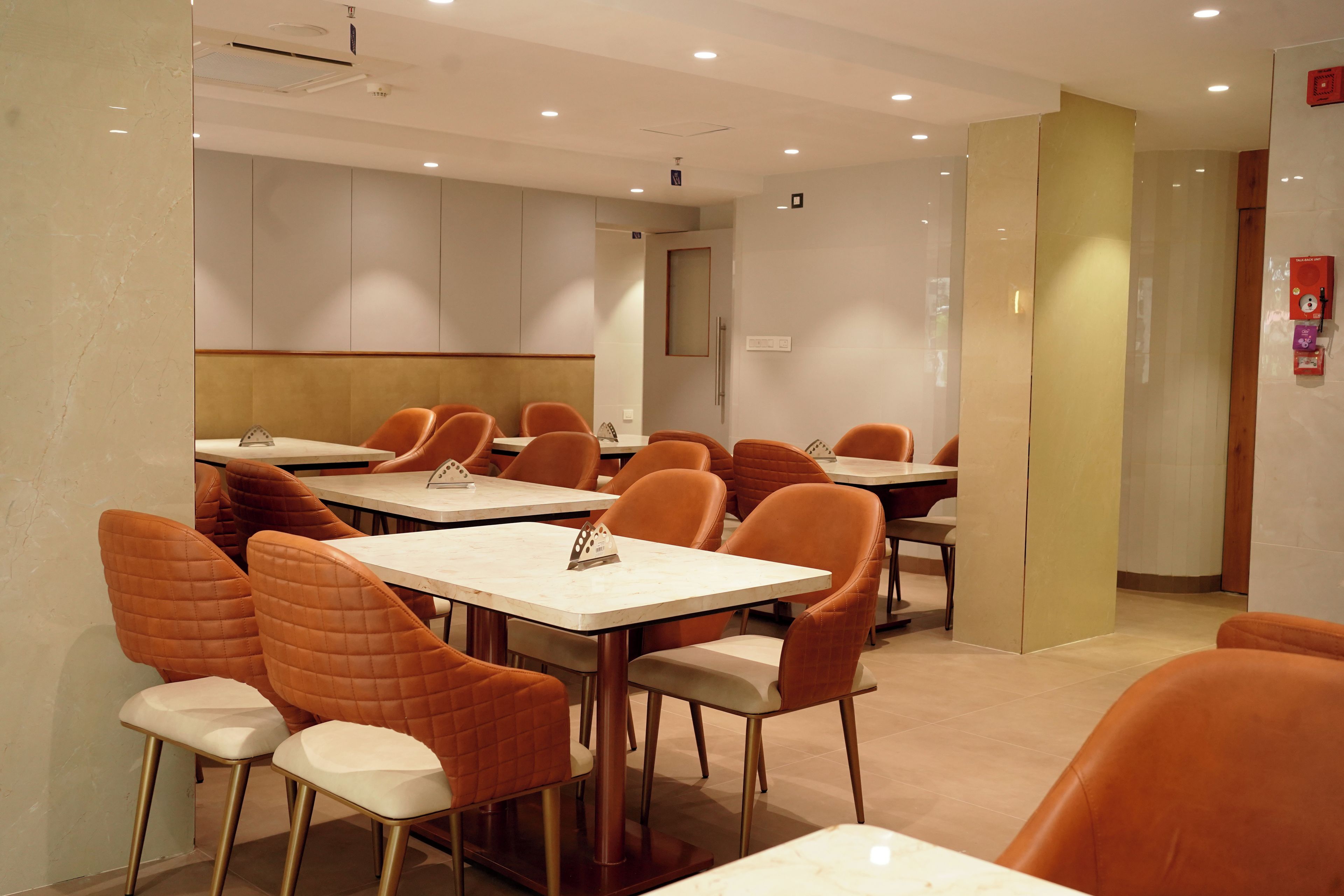 A conference room with tables and chairs, a whiteboard, and a door.