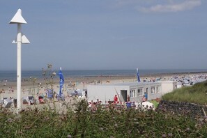 A beach with a white structure, possibly a lifeguard station, and a clear view of the ocean. - Holiday apartment with 2 bedrooms (Norderney)