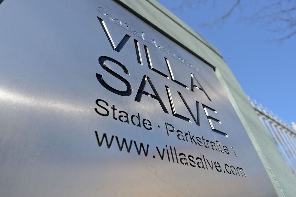 Et skilt med teksten 'VILLA SALVE' og en hjemmesideadresse.