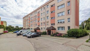 En flervåningsbostadsbyggnad med en parkeringsplats framför.
