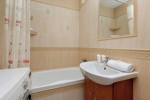 Ein Badezimmer mit Badewanne, Waschbecken und Spiegel.
