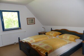 A bedroom with a single bed, a window, a radiator, and a framed picture on the wall. - Thatched holiday home with lighthouse view (Putgarten)