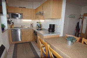 A compact kitchen with a microwave, coffee maker, and a sink. - Holiday apartment with 2 bedrooms (Schönberger Strand)