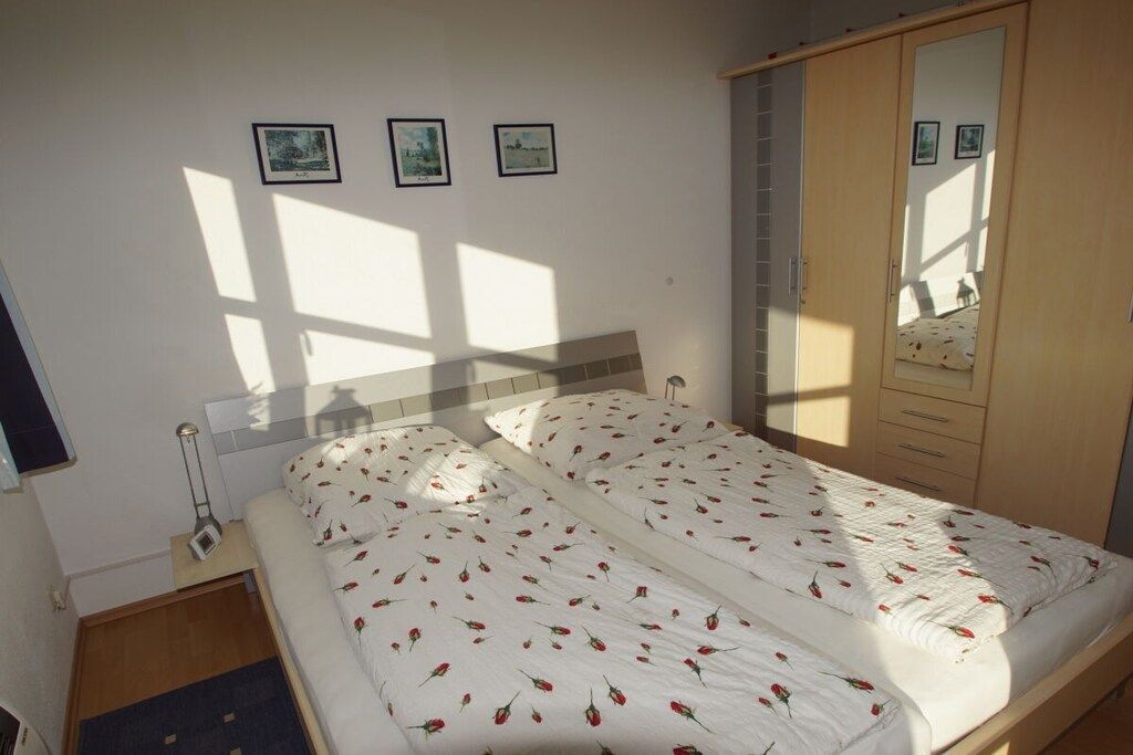 Una camera da letto con un letto, un armadio e un comodino.