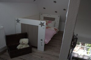 A child's bedroom with a bunk bed, a teddy bear in a chest, and star decals on the walls. - Holiday apartment with 1 bedroom (Ahrenviöl)