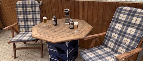 A wooden table with a plaid-patterned chair on each side.
