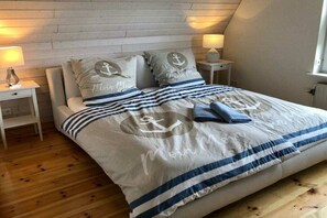 A bedroom with a bed, two nightstands, a lamp, and a window. - Holiday home in Esgrus with swimming pool (Esgrus)