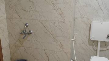 Un baño con pared de mármol, inodoro, bidé y ducha.