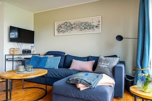 Ein modernes Wohnzimmer mit einer Couch, einem Couchtisch und Kunstwerken an der Wand.