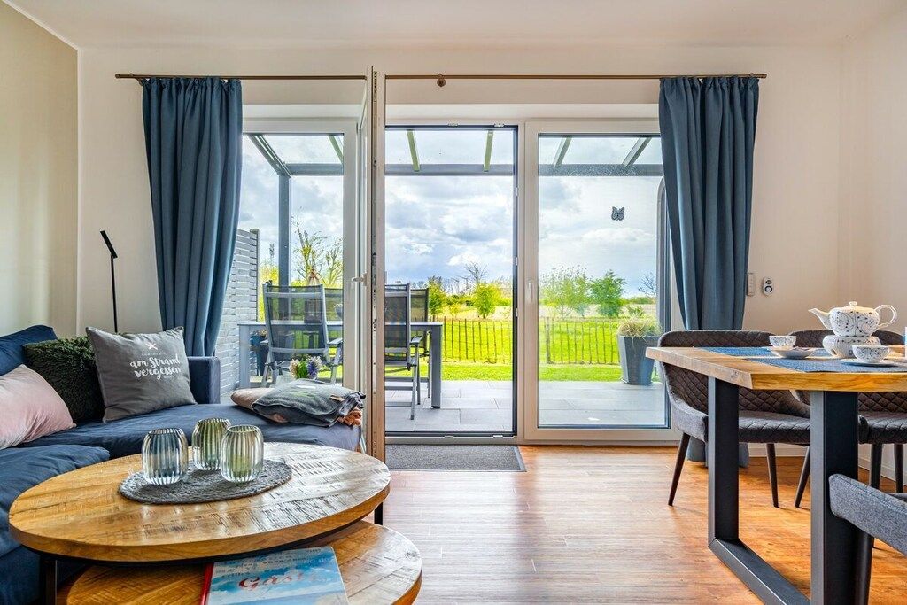 En moderne stue med sofa, sofabord og spiseplads.