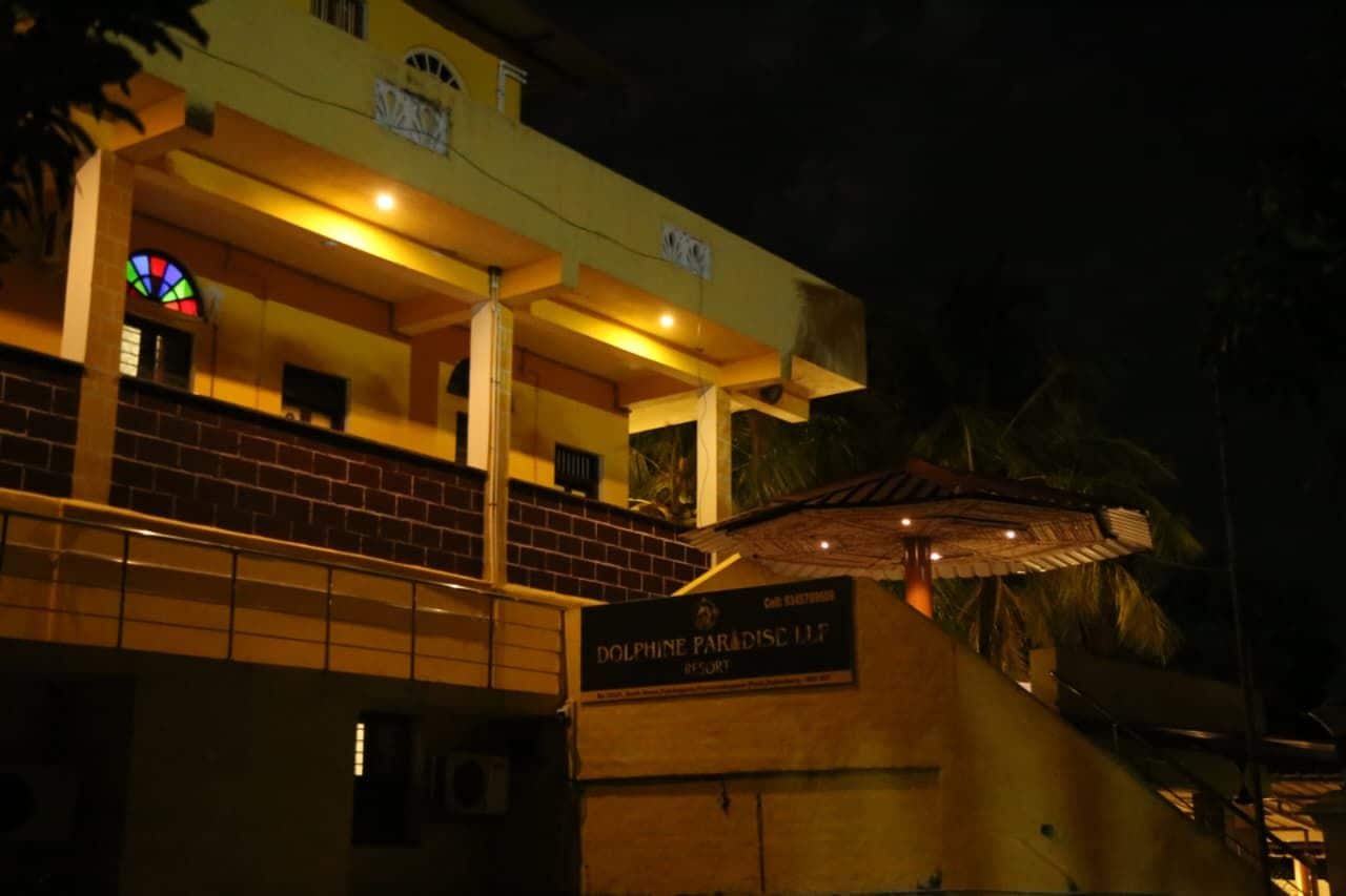A building with a sign reading 'DOLPHINE PARADISE LUF' at night.