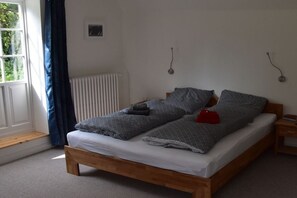 A single bed with a wooden frame, a white mattress, and grey patterned bedding. - Holiday apartment at the Baltic Sea resort (Flensburg)